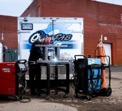 Omnifab mobile welding technician performing on-site welding work with industrial equipment in front of a service trailer
